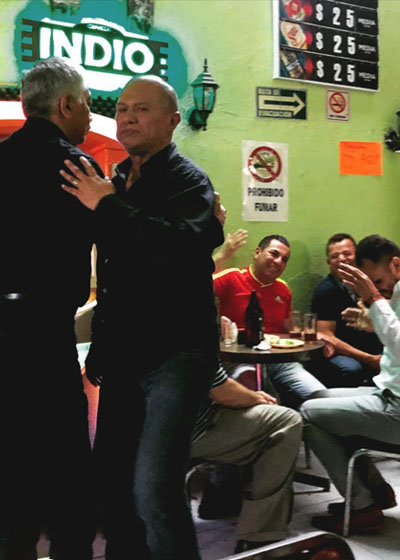 A mature gay couple in a Mexico City bar dancing while others have fun